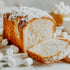 Loaf of cake with powdered sugar on top, surrounded by marshmallows.