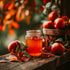Jar of apple cider on a wooden surface with apples and leaves in the background