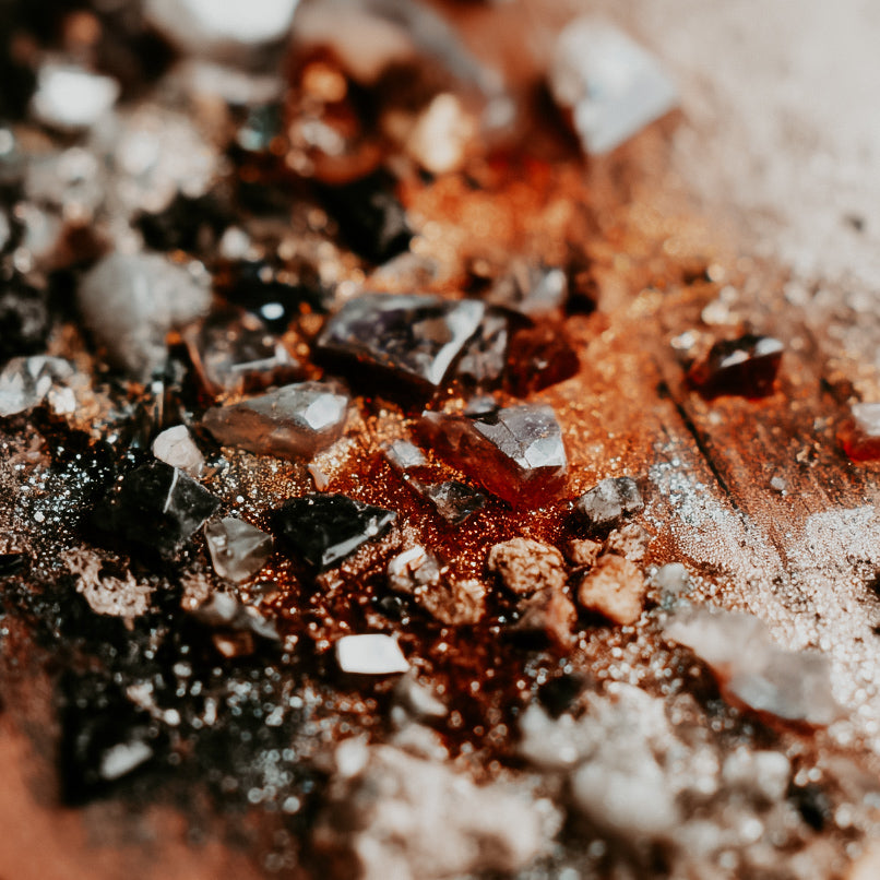 Close-up of dark crystals on a wooden surface