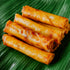 Rolled spring rolls on a green leaf background