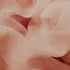 A close-up image of a peach colored textile with a mesh texture.