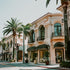 A street view of a luxurious area with palm trees and elegant buildings, reminiscent of Beverly Hills.
