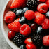 Assorted berries including strawberries, raspberries, and blackberries in a bowl.