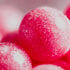 Close-up of pink bubblegum candies with a glittery sugar coating.