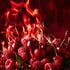 A vivid image of cherries and raspberries with a backdrop of flames, representing the 'Burning Berries' fragrance oil.