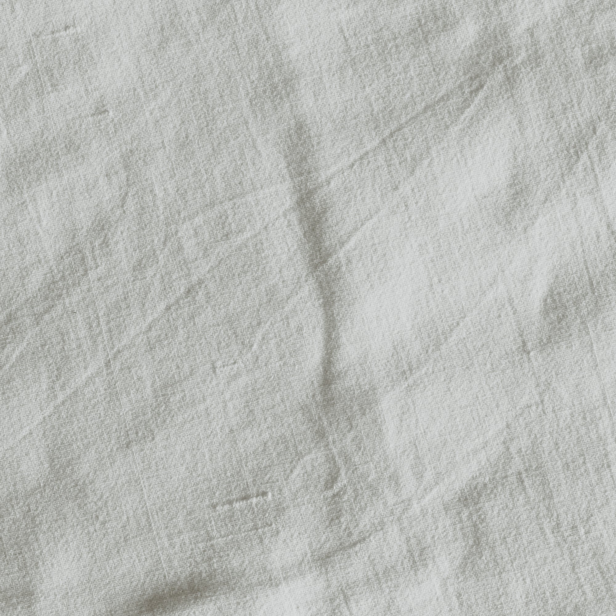 A close-up image of a white canvas texture, likely a fabric material.