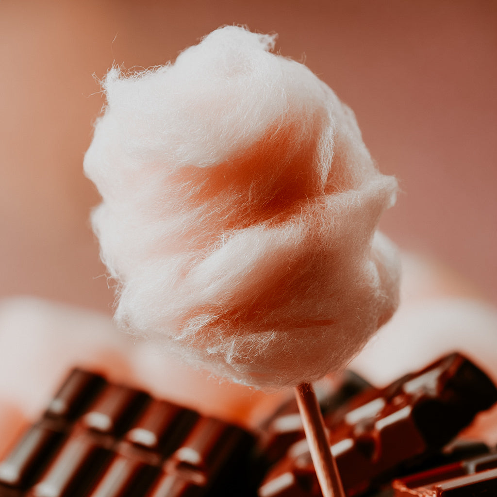 Cotton candy on a stick with chocolate bars in the background