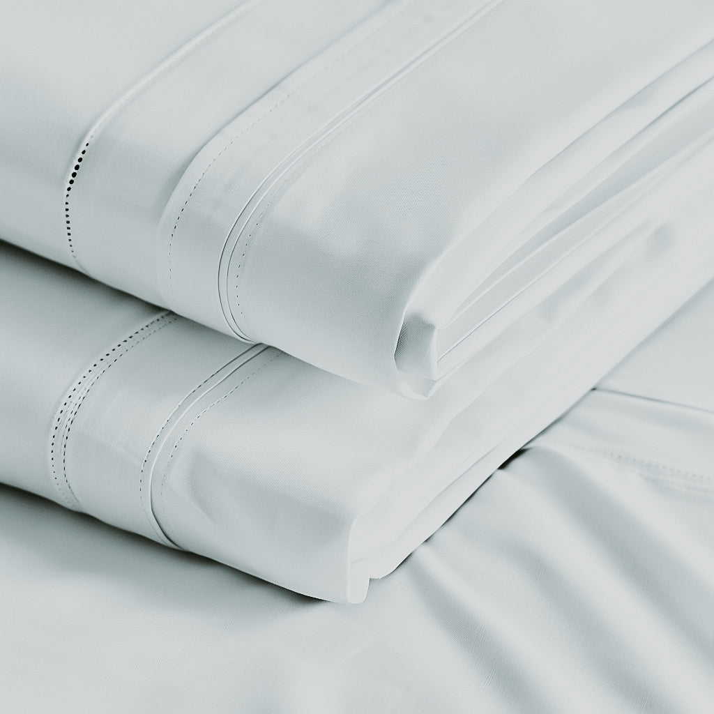 A folded white Egyptian cotton sheet with detailed stitching.