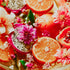 Fruits and flowers arranged together with dragon fruit, oranges, and pink flowers.