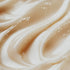 Close-up of a creamy, beige-colored fragrance oil with a smooth texture, possibly containing glitter or fine particles for visual appeal.