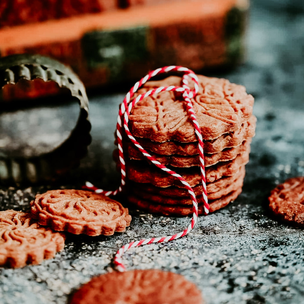 A stack of cookies tied with a red and white string, reminiscent of holiday baking.