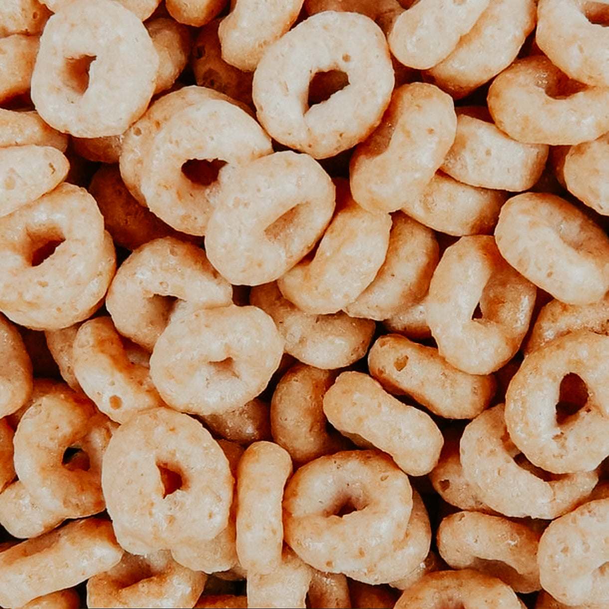 A close-up image of Honey Nut Cheerios cereal loops.