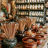 A display of incense sticks and fragrance oils in a store, with various containers holding incense pellets or oils arranged on a table.