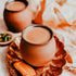A  cup of Indian chai tea with milk and spices, served with a cookie.