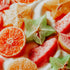 Close-up of sliced fruits including oranges, watermelon, and star fruit on a white background.