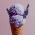 Purple lavender ice cream in a cone with lavender flowers on a pink background