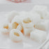 A photo of lychee jelly pieces on a white surface.