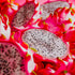 A close-up image of a neon pink dragonfruit with a slice removed to reveal the white seed-speckled interior.