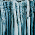 A collection of blue denim jeans hanging.