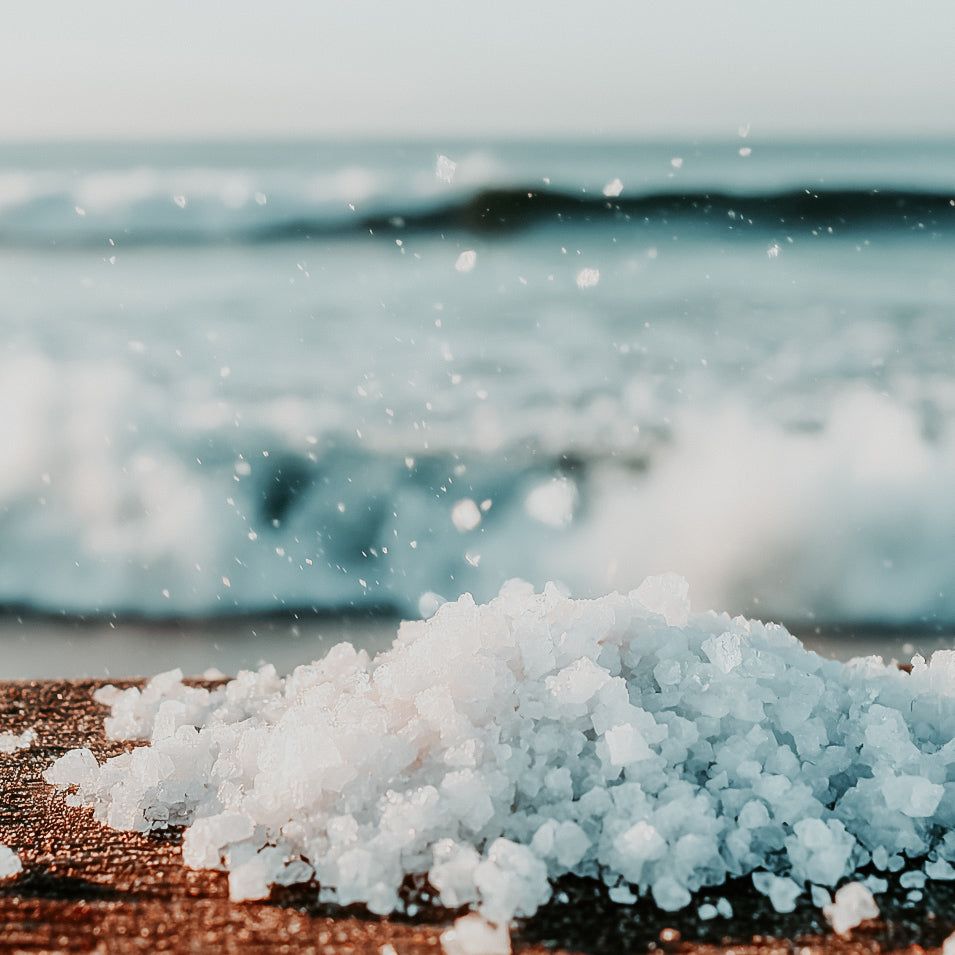 Close-up of salt crystals with ocean waves in the background