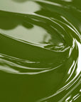 A close-up image of a olive green liquid candle dye.