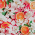 A colorful fragrance oil product image featuring slices of orange and marshmallows with white flowers on a pink background.
