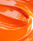 Close-up of a highly concentrated orange liquid candle dye.