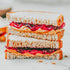 A sandwich with peanut butter and jelly spread between two slices of bread, placed on a white surface.