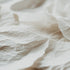 A close-up image of crumpled white paper, emphasizing texture and the soft, minimalist theme of the fragrance oil.
