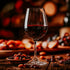 A glass of port wine on a table with scattered dried fruits and a soft, warm background.