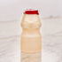 A a bottle of Yakult with a red cap on a marble surface.