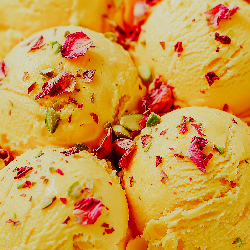 Yellow ice cream with rose petals and pistachios on a yellow background