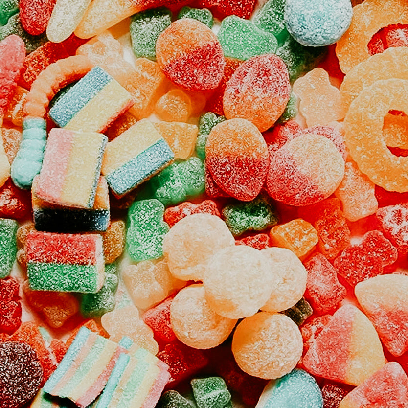 A colorful assortment of various sour gummy candies.