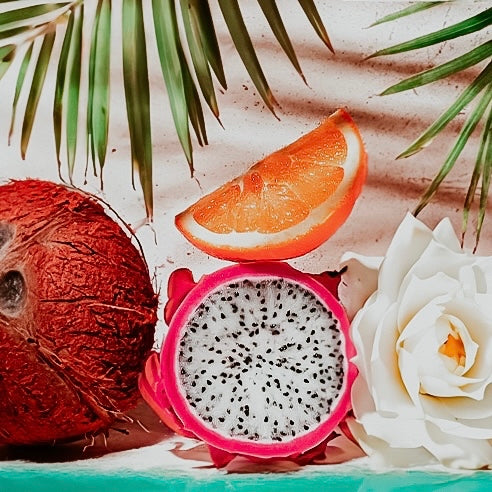 A fragrance oil product with a tropical theme, featuring a coconut, an orange slice, and a flower.