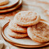 Stack of sugar cookies on a ceramic plate with a soft focus background