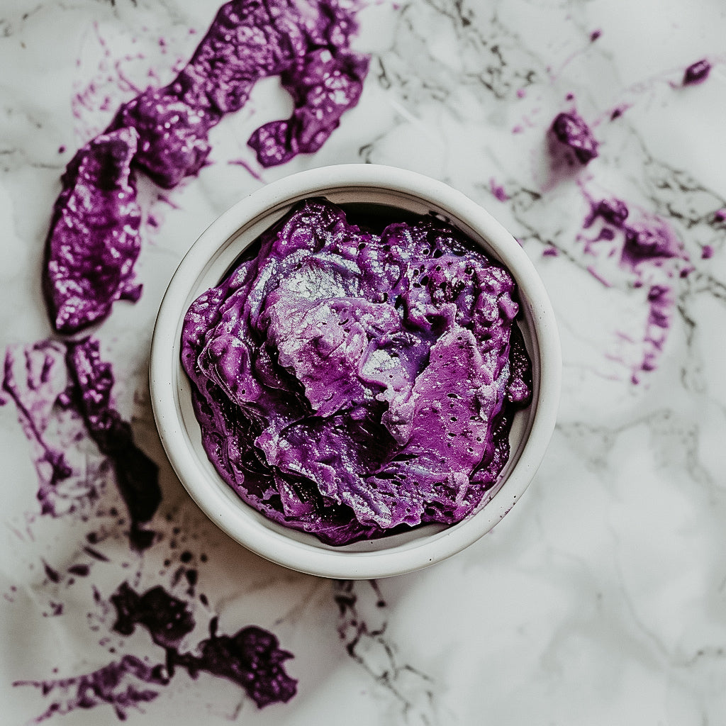 A small open container of ube jam spilled over the sides on a marble surface.