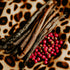 A photo of vanilla beans and red berries arranged around it, placed on a surface with a leopard print pattern.