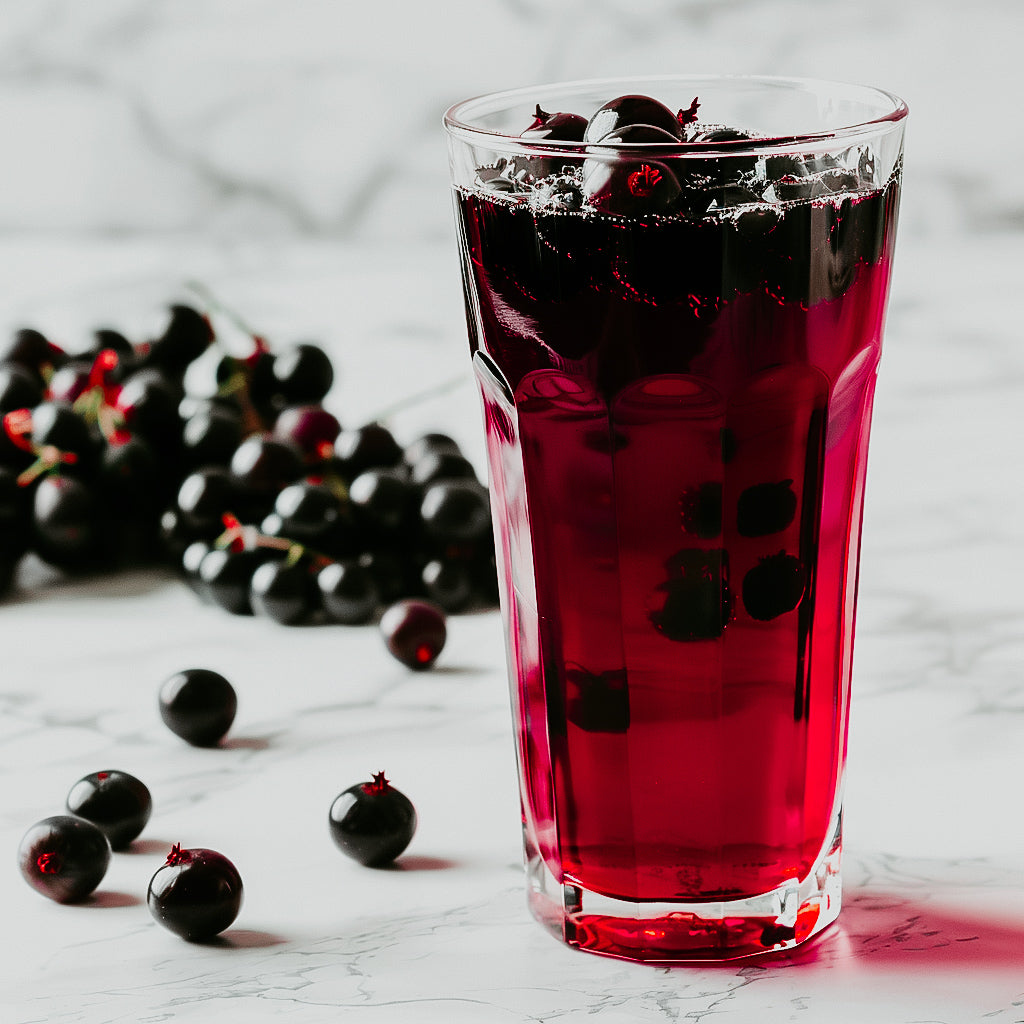 a photo of a glass of vimto soda with blackcurrant fruits