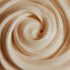 A close-up image of a swirling, creamy white fragrance oil with small glitter particles, suggesting a lush and indulgent texture.