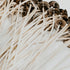 A close-up of zinc-core wicks with braided cotton exterior, prepared for candle making.