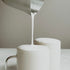 Steamed milk being poured into a cup